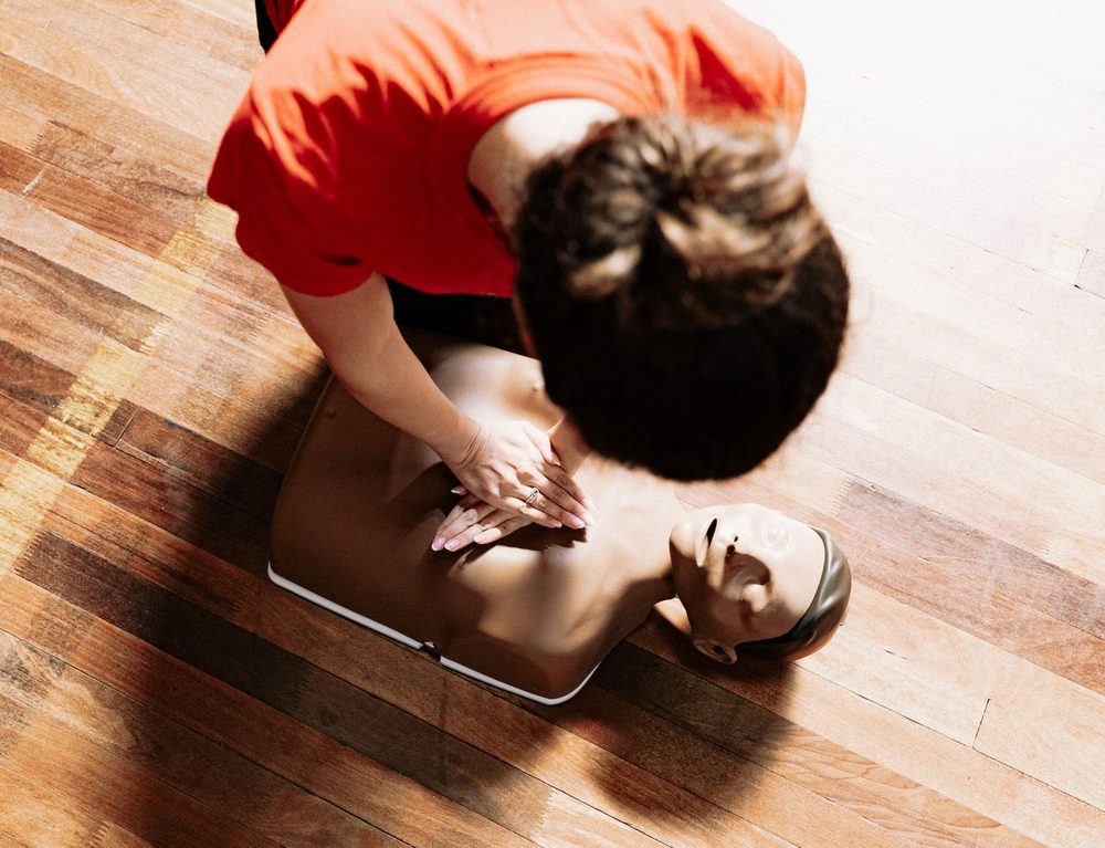Secouriste pratiquant un massage cardiaque sur mannequin lors d'une formation aux gestes d'urgence